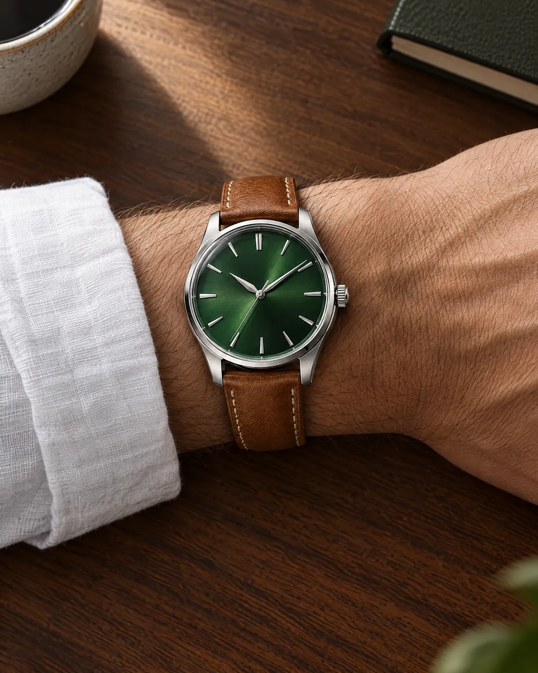 Top view of the watch on a wrist of about 17 cm, resting on a walnut desk.