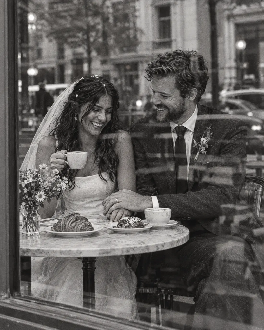 Black and white: the couple share coffee and pastries at a cafe window table after the ceremony.